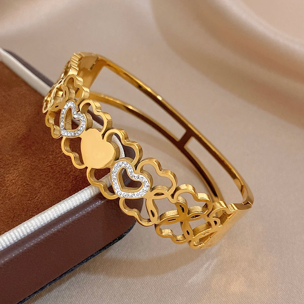 Gold cuff bangle with alternating hollow heart links and clear rhinestone heart inlays