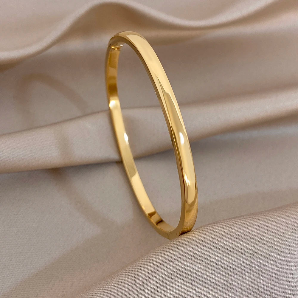 Single gold-tone cuff bangle bracelet with smooth polished finish