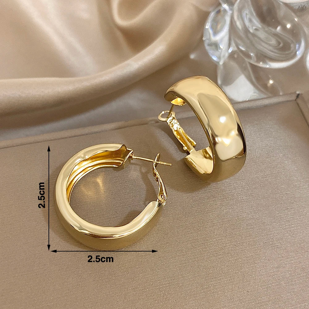 Gold-tone chunky hoop earrings, approximately 2.5 cm wide and tall