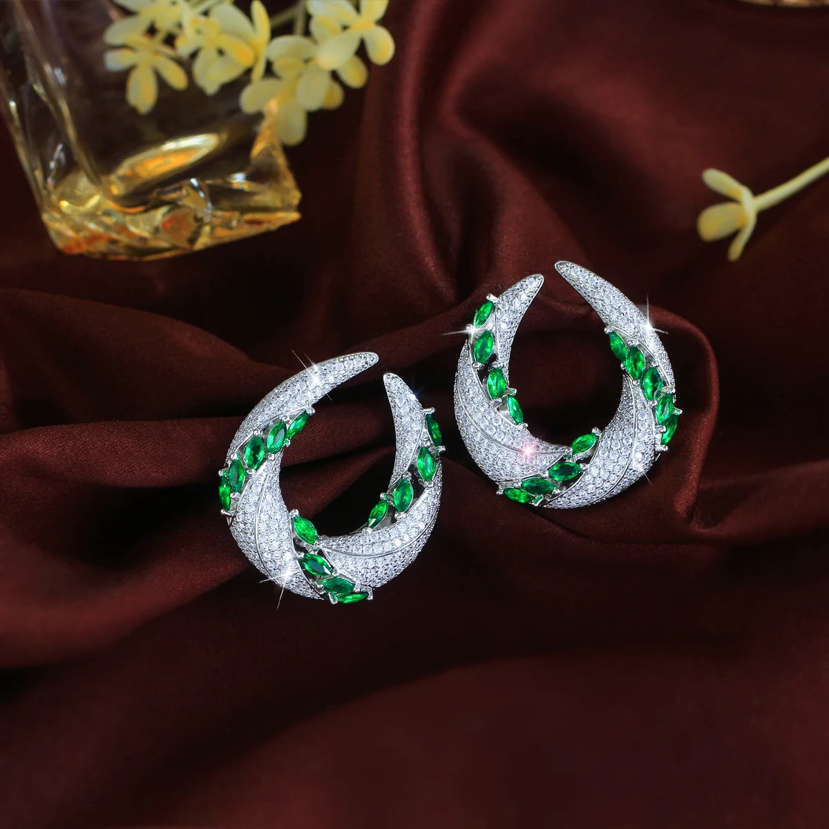 Cubic zirconia crescent drop earrings with green and white stones