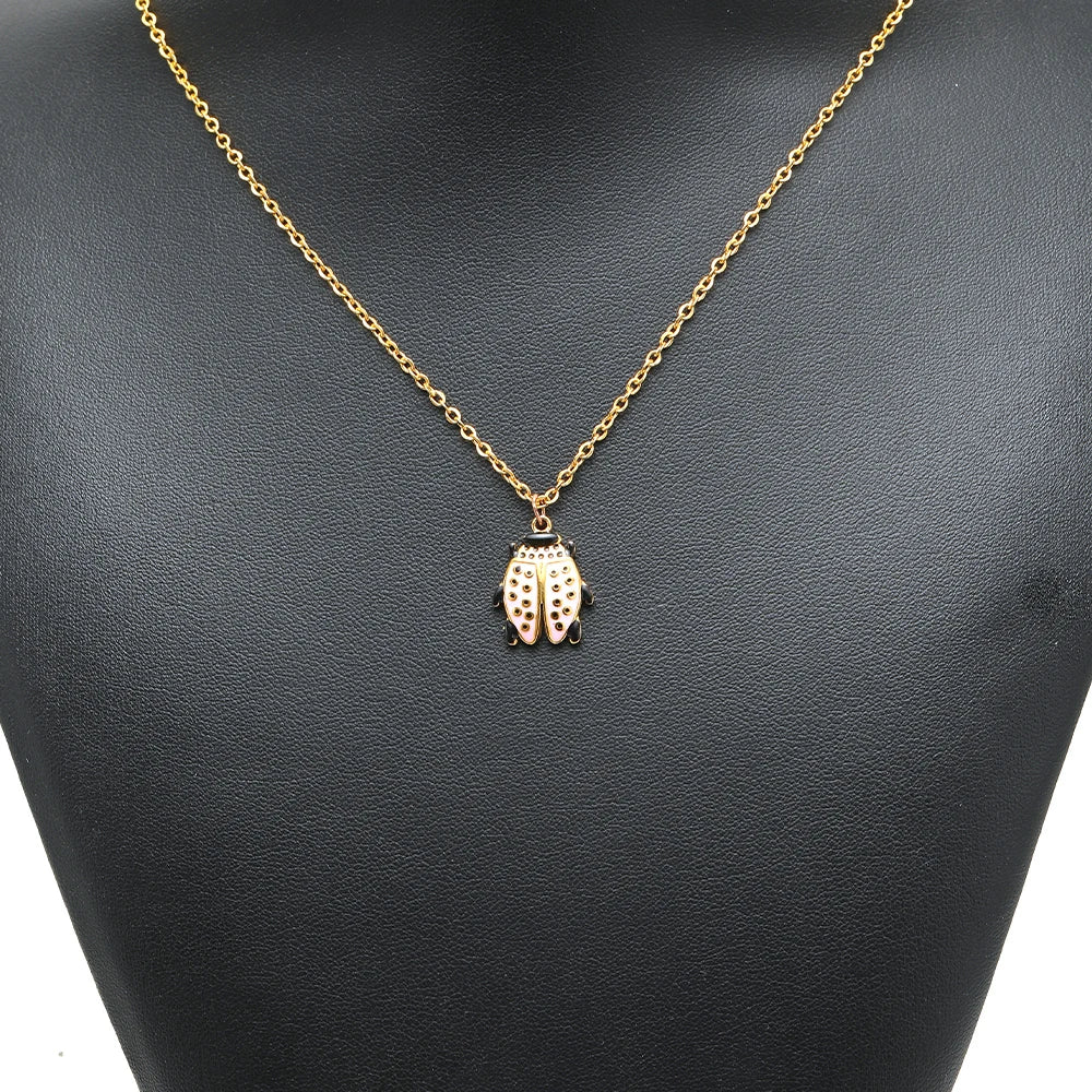 Gold beetle charm pendant on a chain necklace