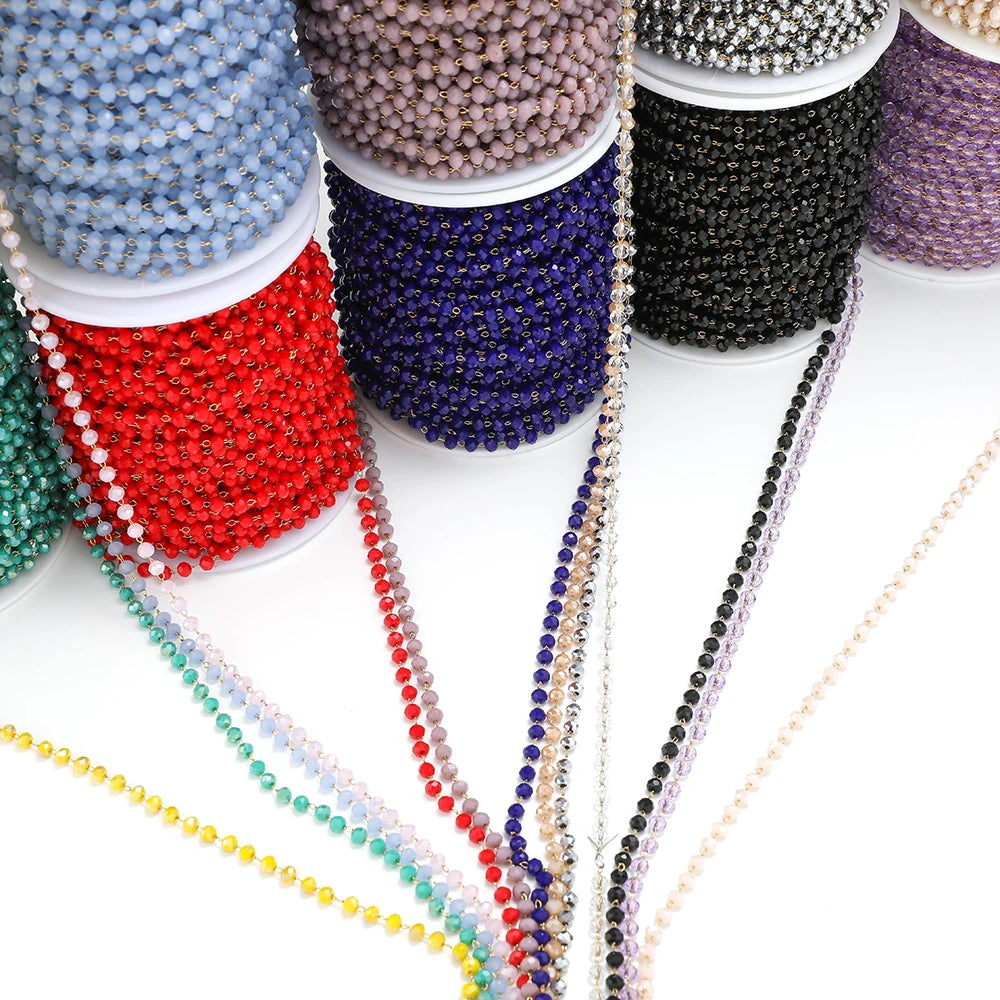 Assorted faceted beaded chains on spools in blue, red, navy, black, and white