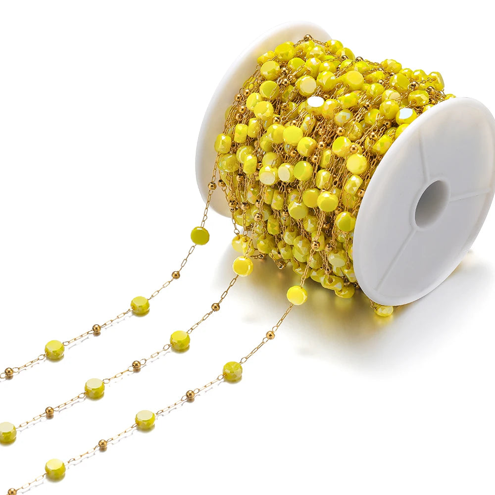 Yellow crystal bead chain with gold links wrapped on a white spool for jewelry making