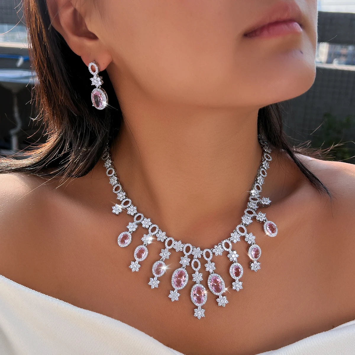 Pink oval stone necklace with floral crystal drops, shown worn with a matching earring