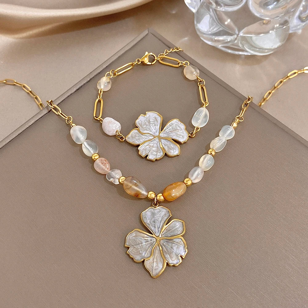 Gold plated necklace with white and pale beads and white enamel flower pendant