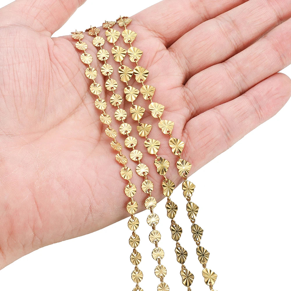 Gold heart-shaped embossed link chain held in a hand