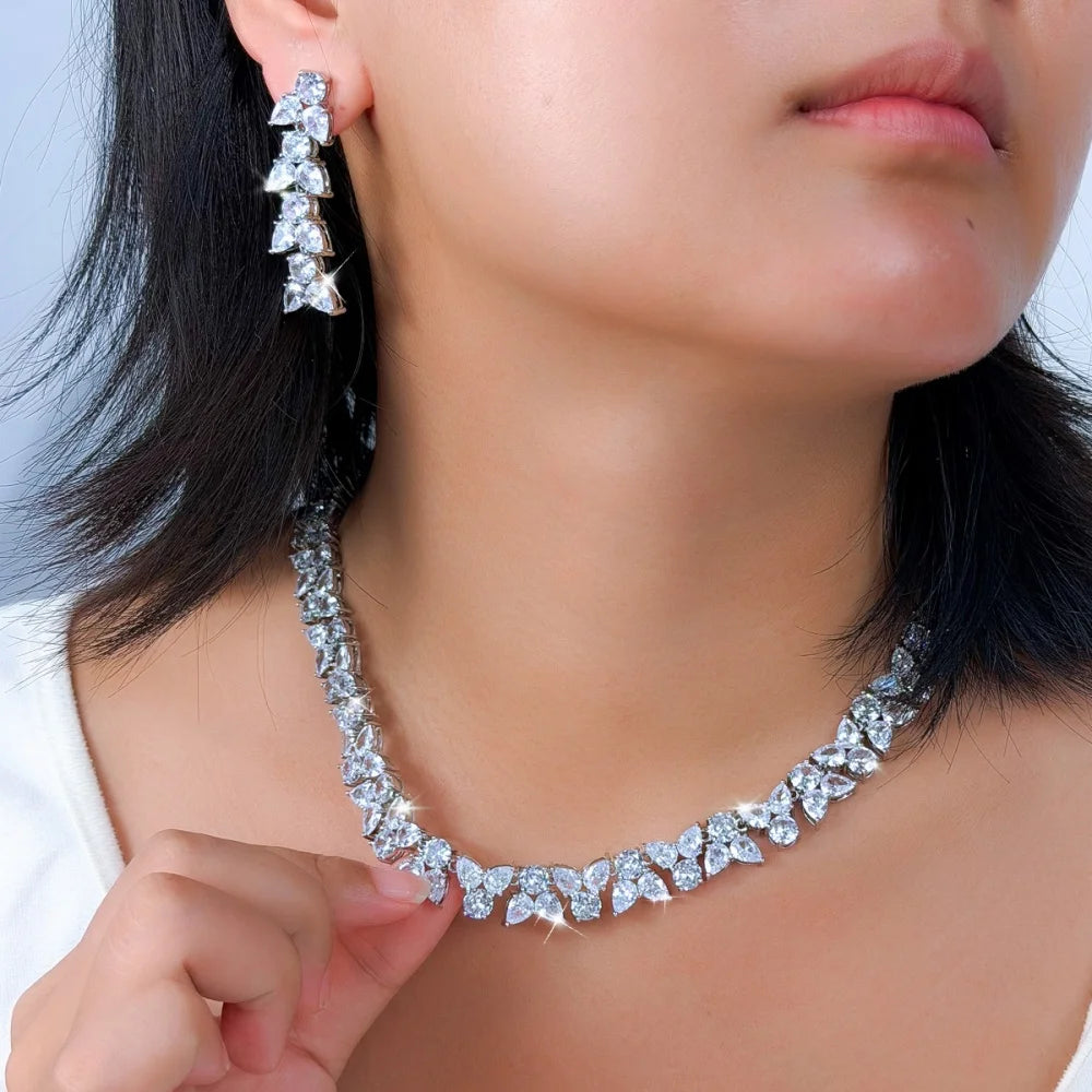 Clear zirconia leaf necklace and dangling earrings worn as a jewelry set