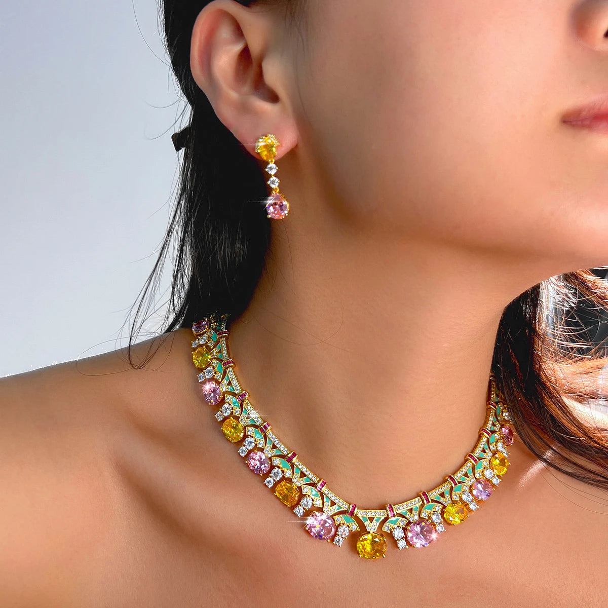 Gold-tone multicolor cubic zirconia drop earrings with matching necklace, model close-up