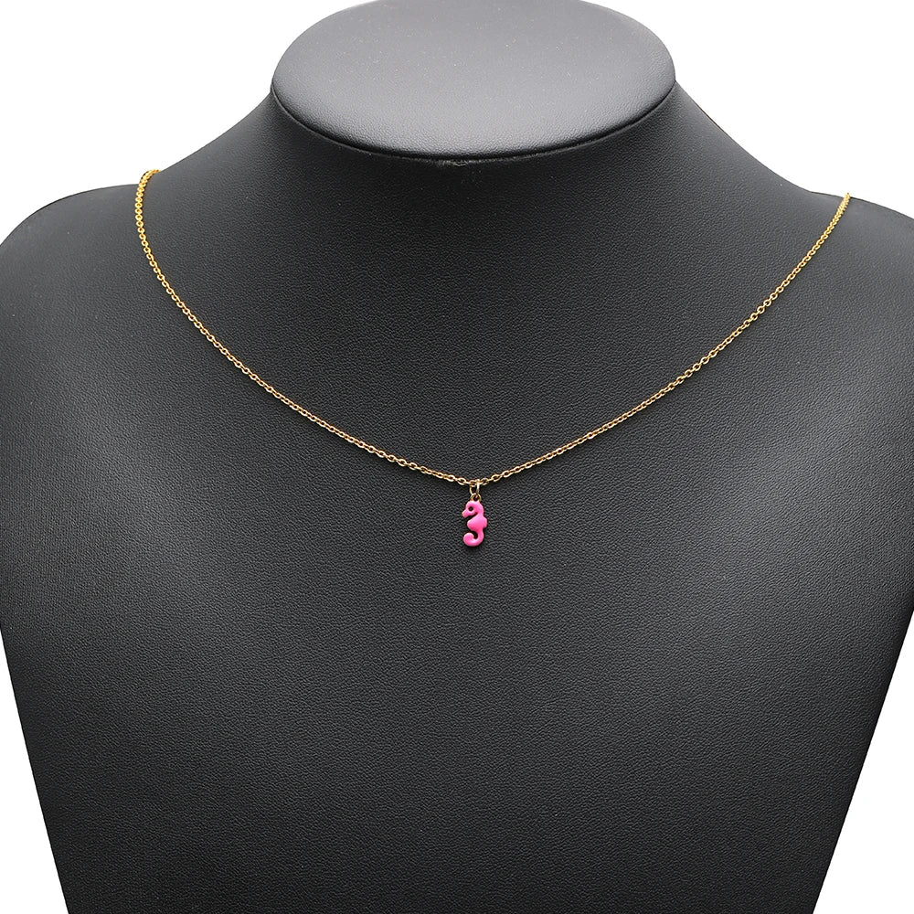 Pink seahorse charm pendant on a gold chain necklace