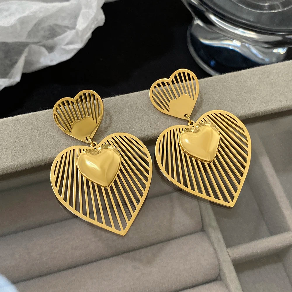 Gold dangling heart earrings with striped openwork hearts and raised heart charms