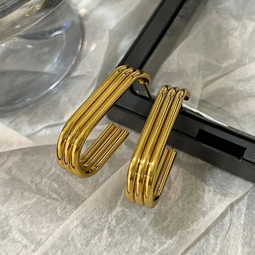 Gold-tone U-shaped hoop earrings with glossy, ridged tubular bands