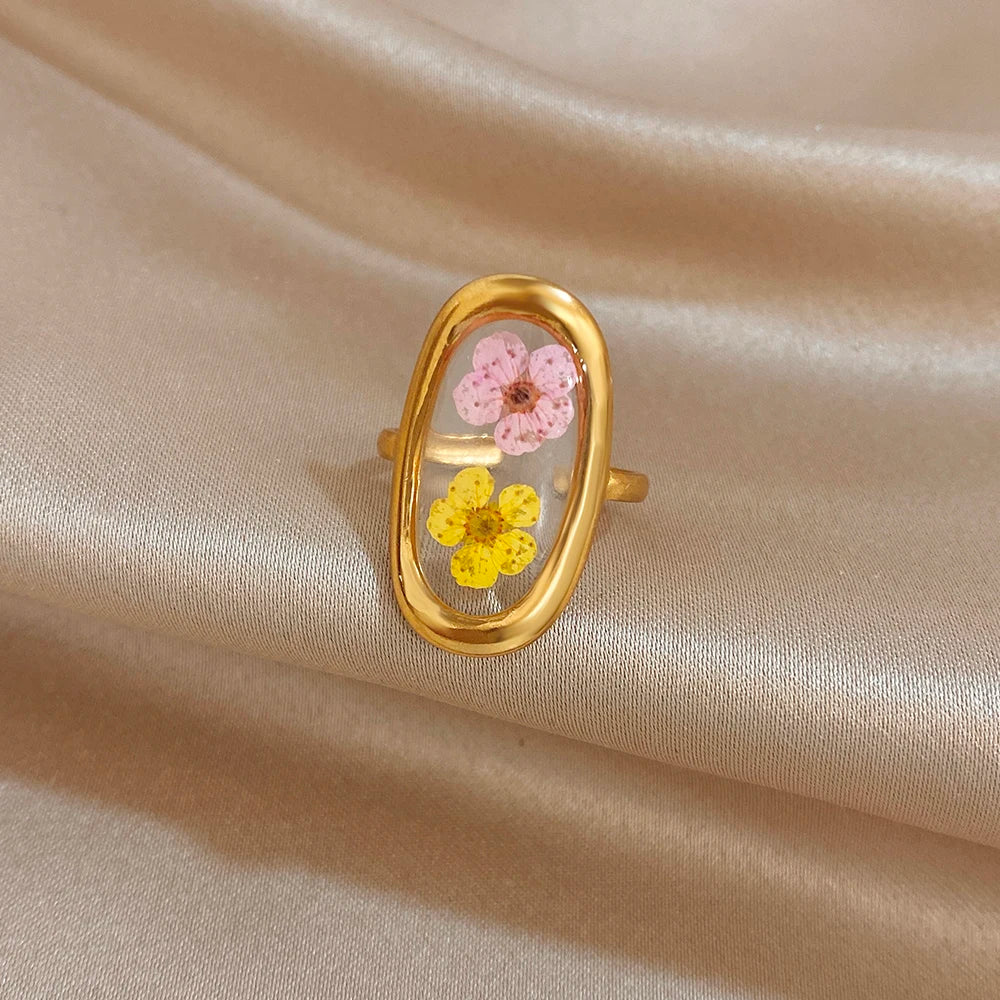 Gold-tone open oval ring with pink flower center and yellow blossom