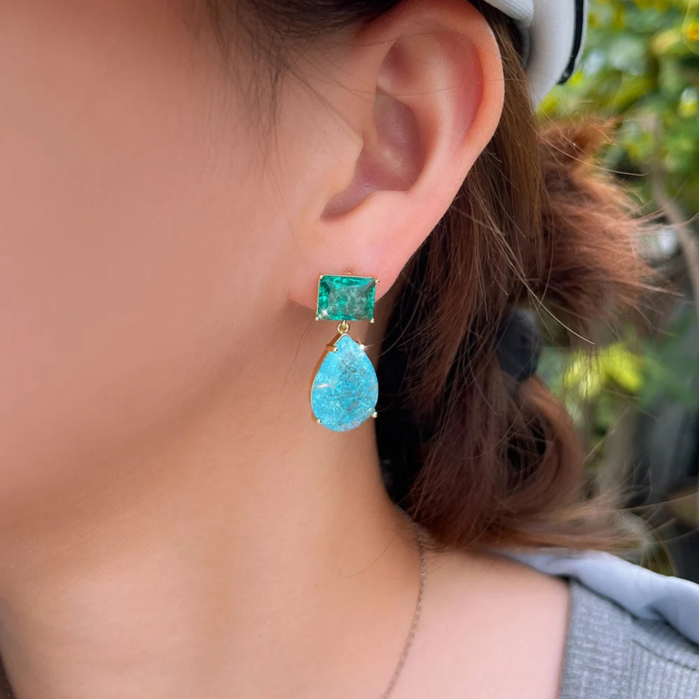 Green and blue stone drop earring worn, with a square stud and teardrop pendant