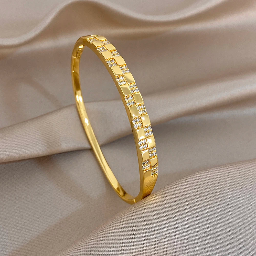 Gold-plated cuff bangle with slim band and evenly spaced square zirconia