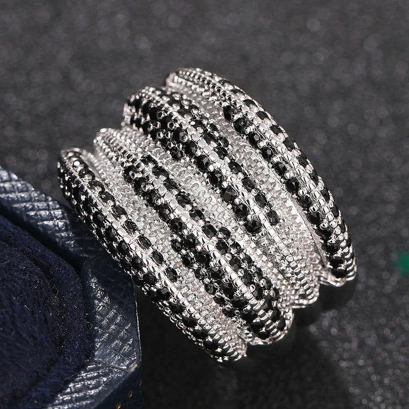 Wide ring with alternating rows of black and clear stones across its ridged top