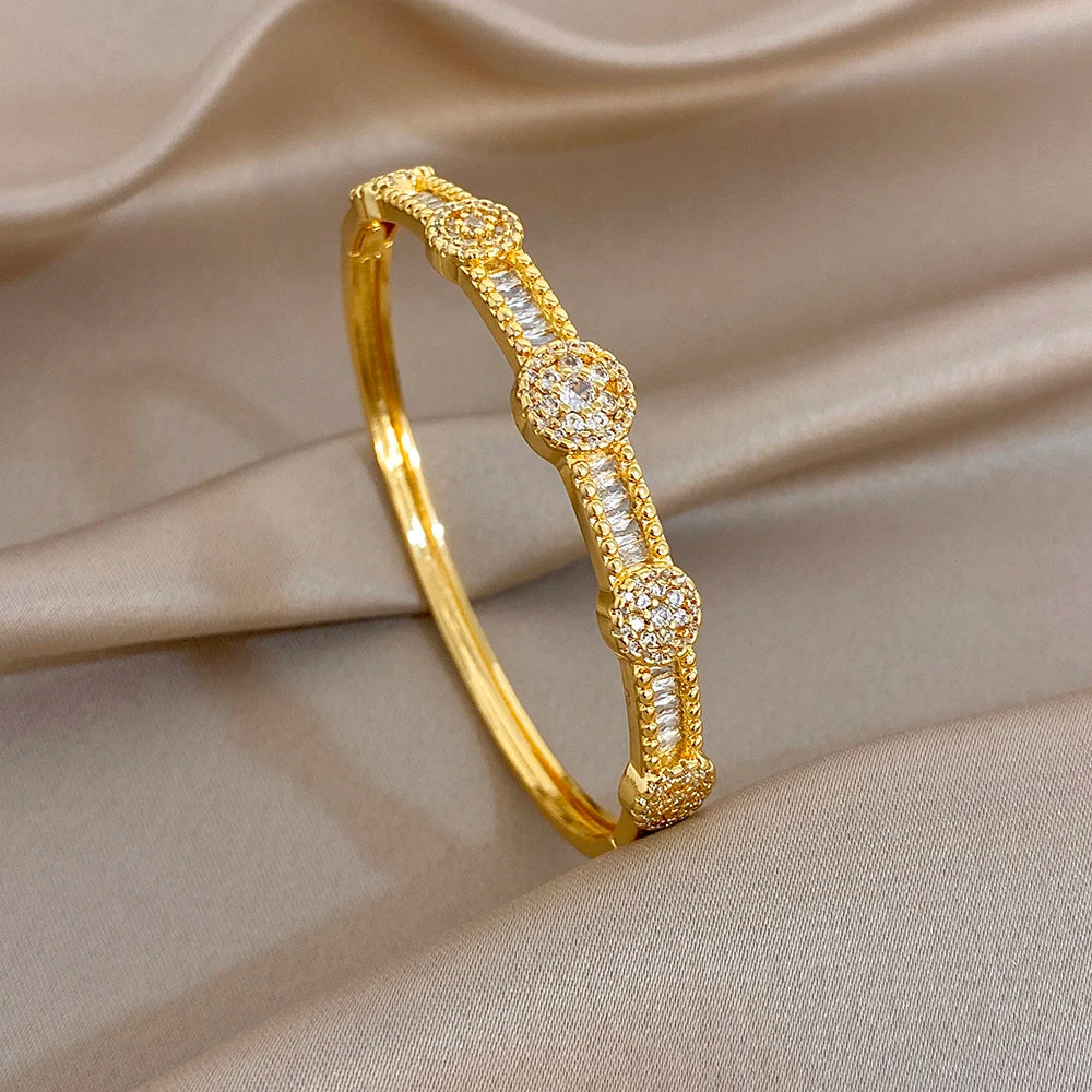 Gold-plated cuff bangle with round zircon floral accents and twisted band