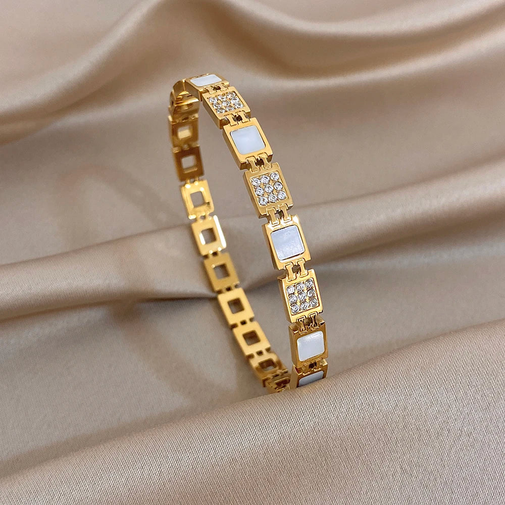 Gold-plated square-link cuff bangle with clear crystal rows and small square insets