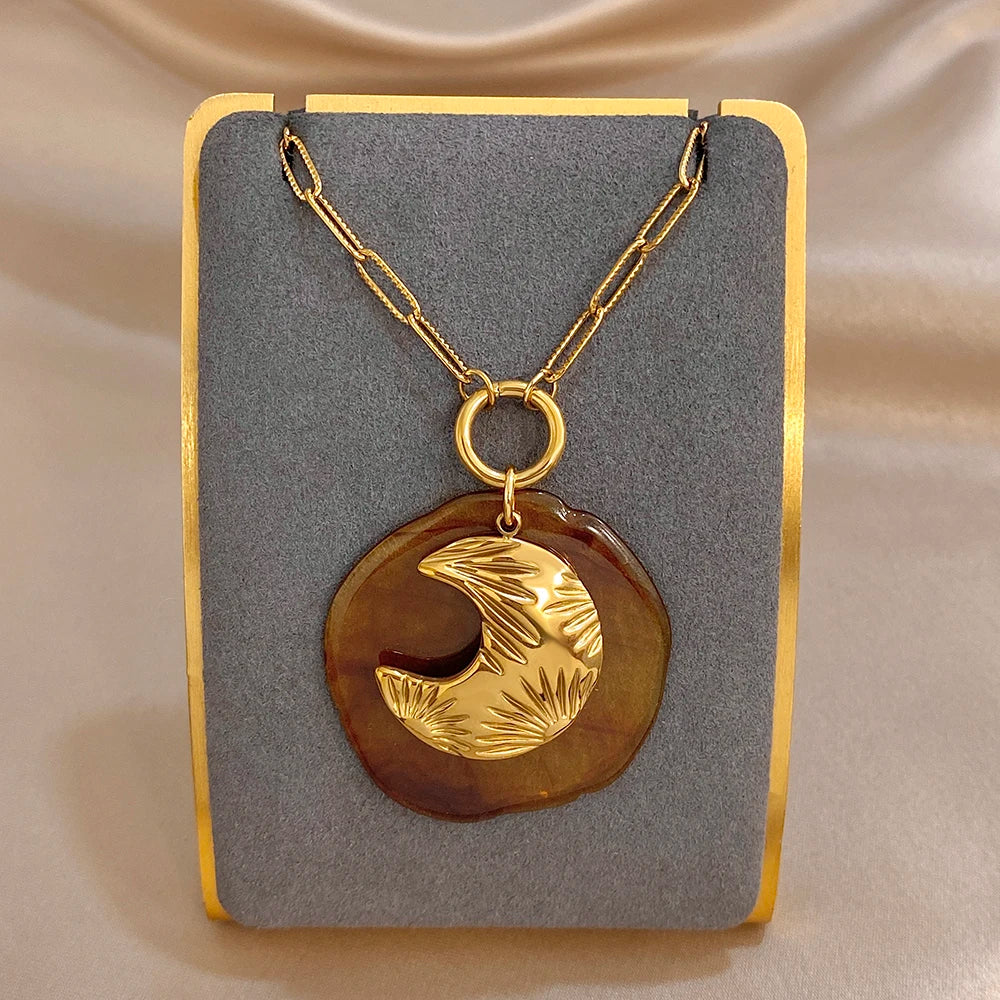 Gold-tone chain pendant necklace with large amber round moon charm and gold crescent motif