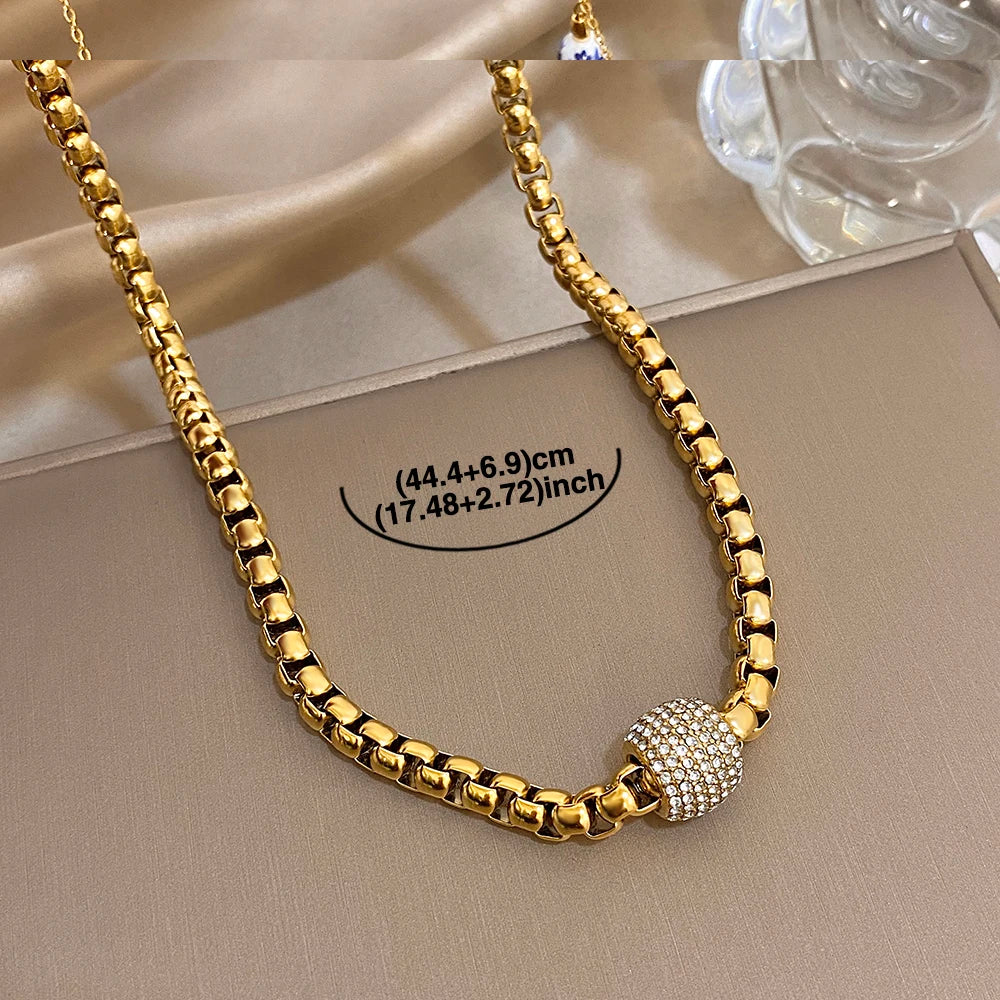 Gold-tone chunky chain choker necklace with round rhinestone center bead