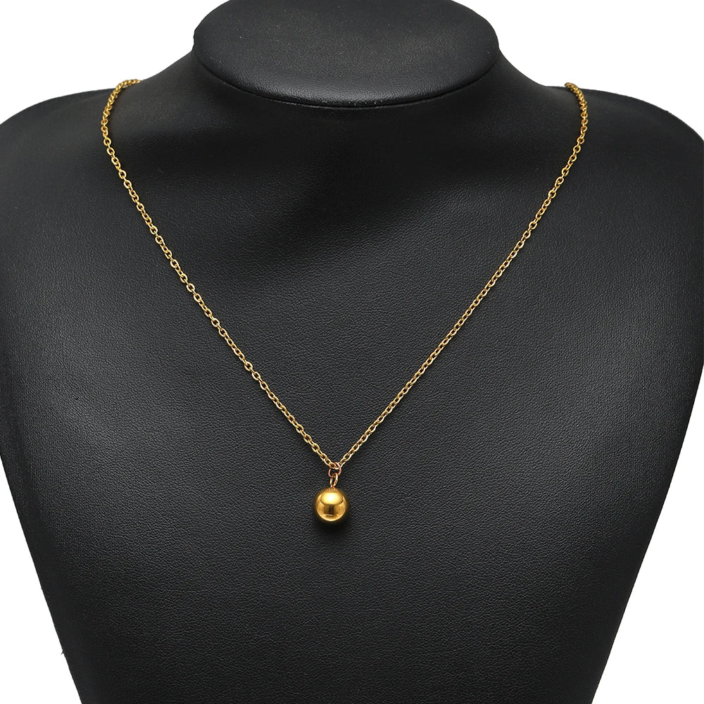 Gold plated ball pendant necklace on a black mannequin bust, solid round charm