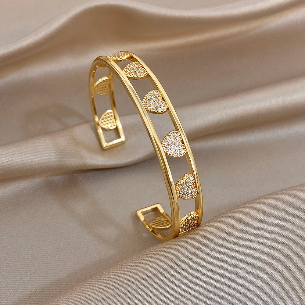 Gold heart zirconia cuff bangle set with circular heart motifs and stone details