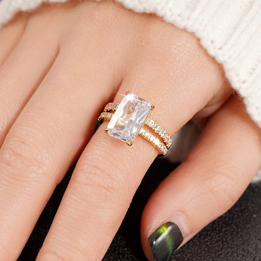 Rectangular cubic zirconia ring set with large clear stone and gold-tone bands