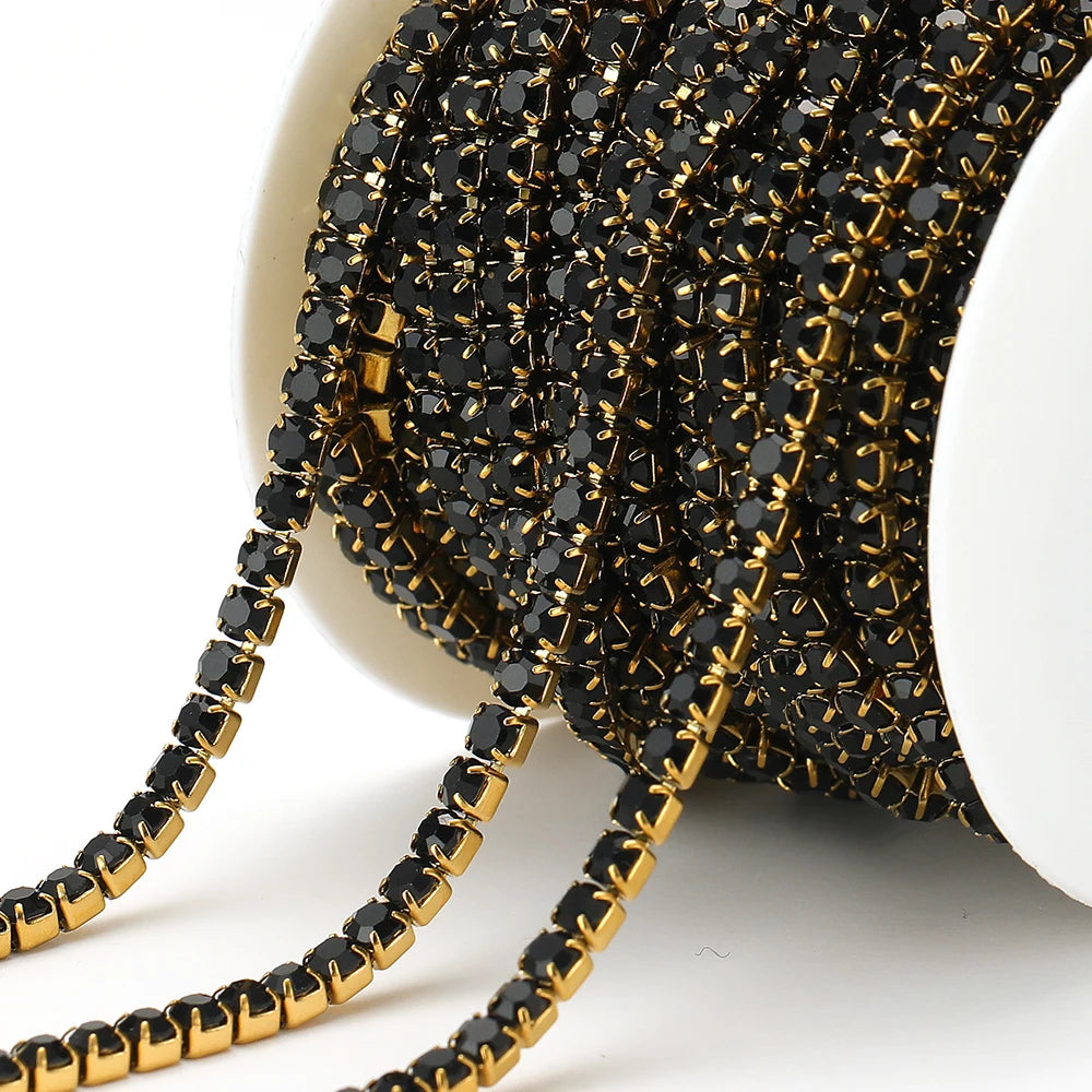 Black rhinestone chain tassel with gold-tone links on white spool