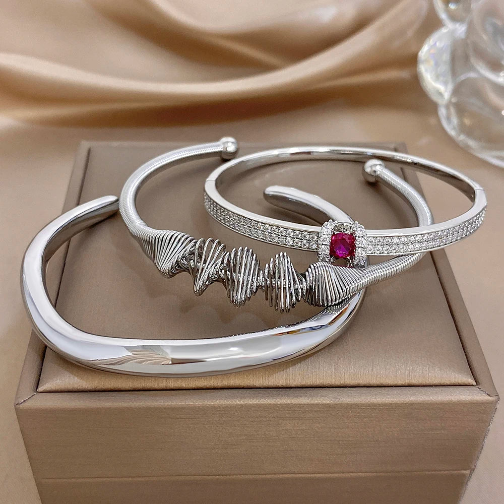 Silver cuff bangle set with textured band and red gemstone detail, stackable bracelets