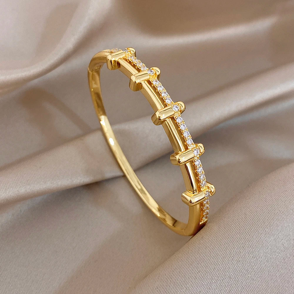Gold-tone zircon geometric cuff bangle with aligned pave bar and bezel links
