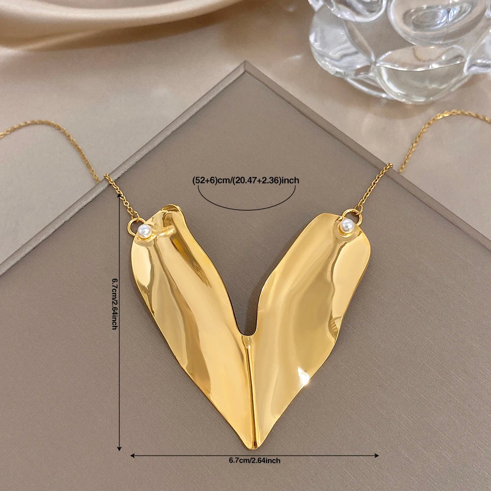 Gold-tone heart pendant collar necklace, irregular glossy V-shape with two pearl accents