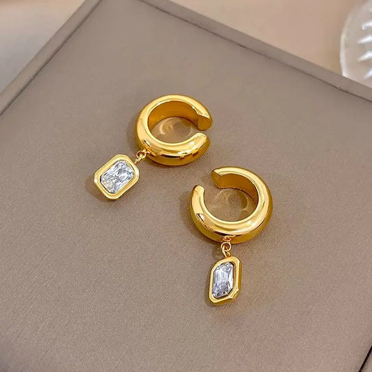 Gold-tone hoop ear clip earrings with dangling square zirconia charms