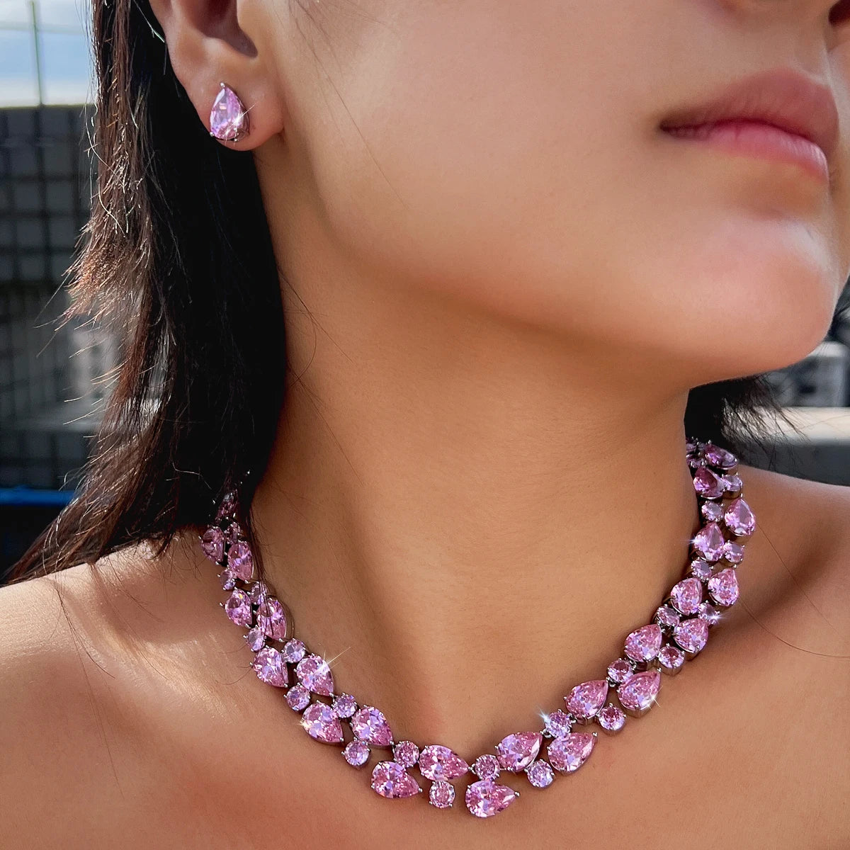 Pink crystal teardrop jewelry set with matching drop earrings, worn on model