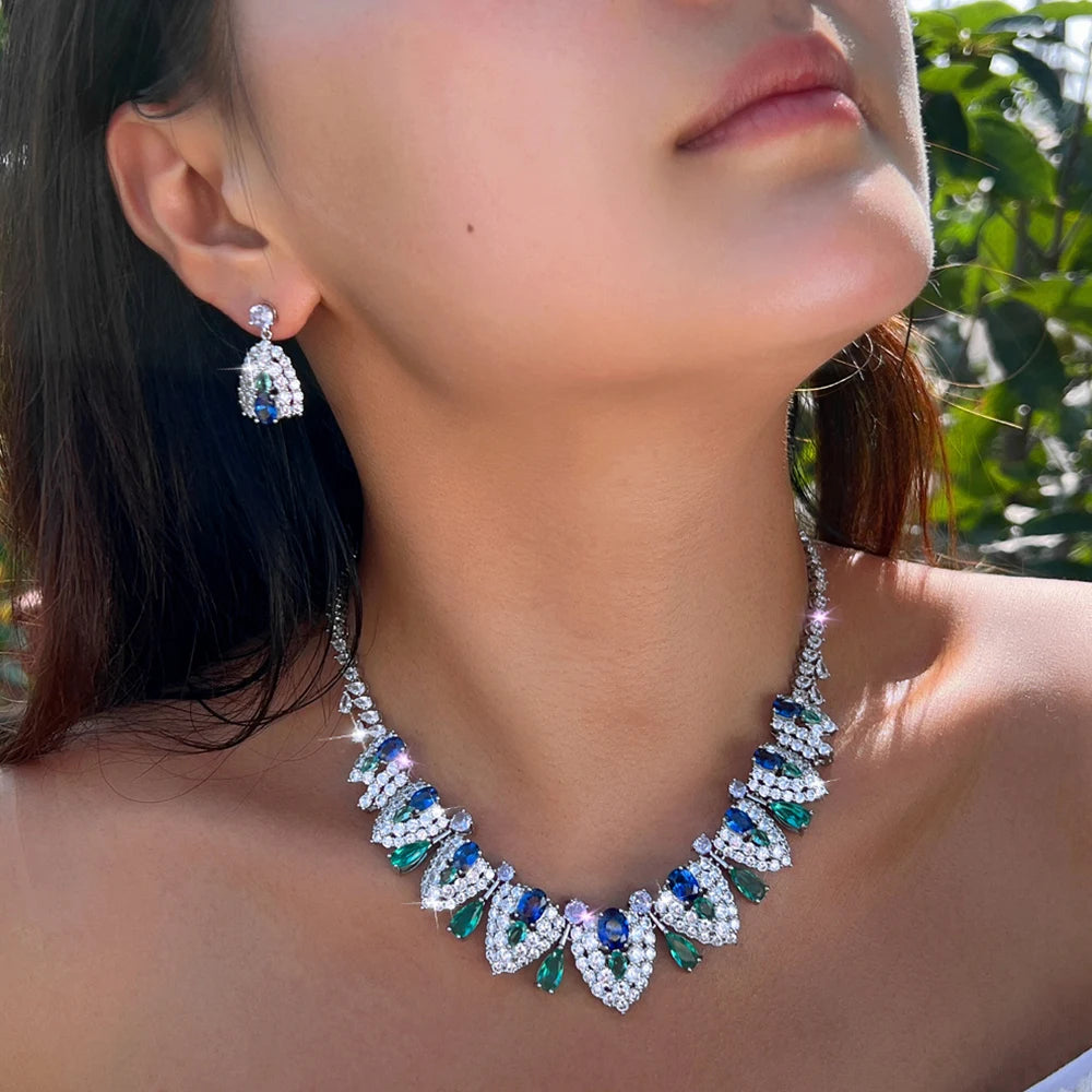 Jeweled necklace and teardrop earring worn by a model, with blue and green stones