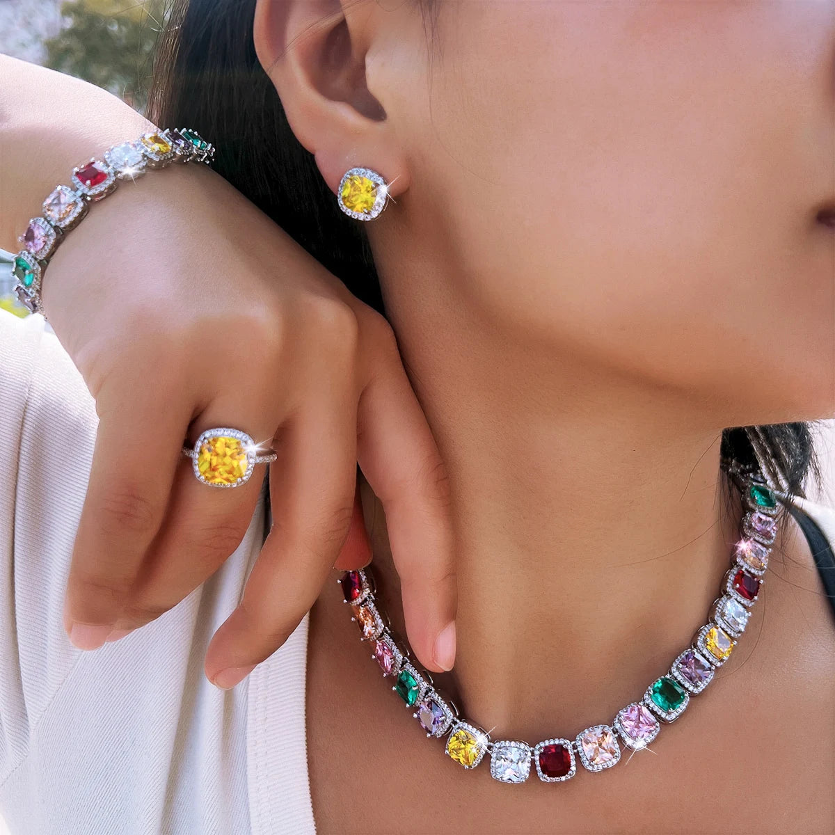 Multicolor CZ jewelry set worn: tennis necklace, bracelet, ring, and stud earrings, silver-tone