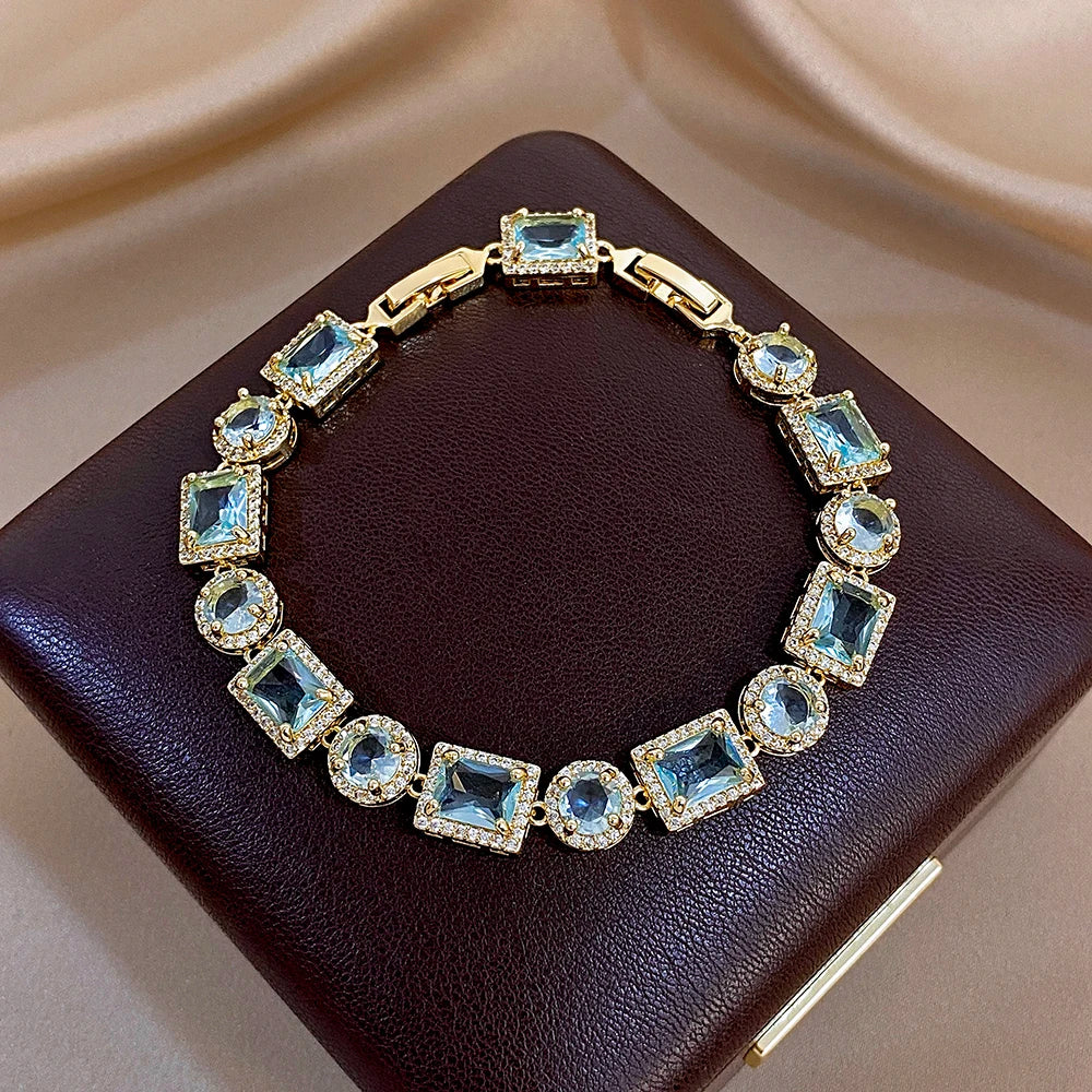 Gold-tone geometric link bracelet with blue square and round crystal stones, even sparkle
