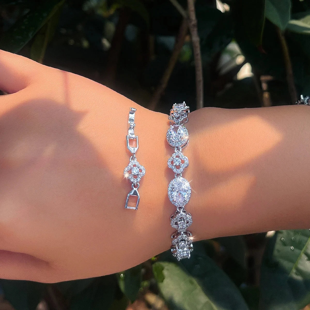 Clear crystal flower tennis bracelet worn on a wrist, with clasp visible