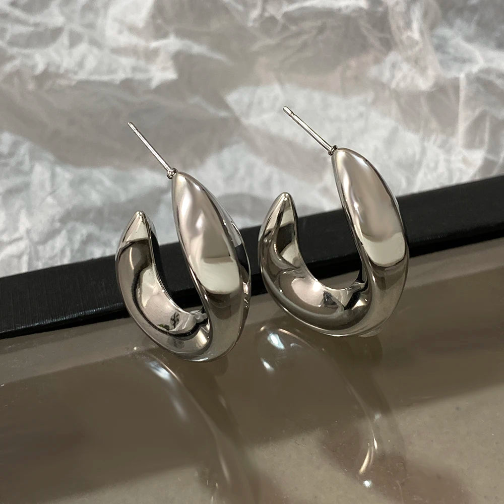 Silver-tone chunky hoop earrings with glossy sculpted curves and post backs