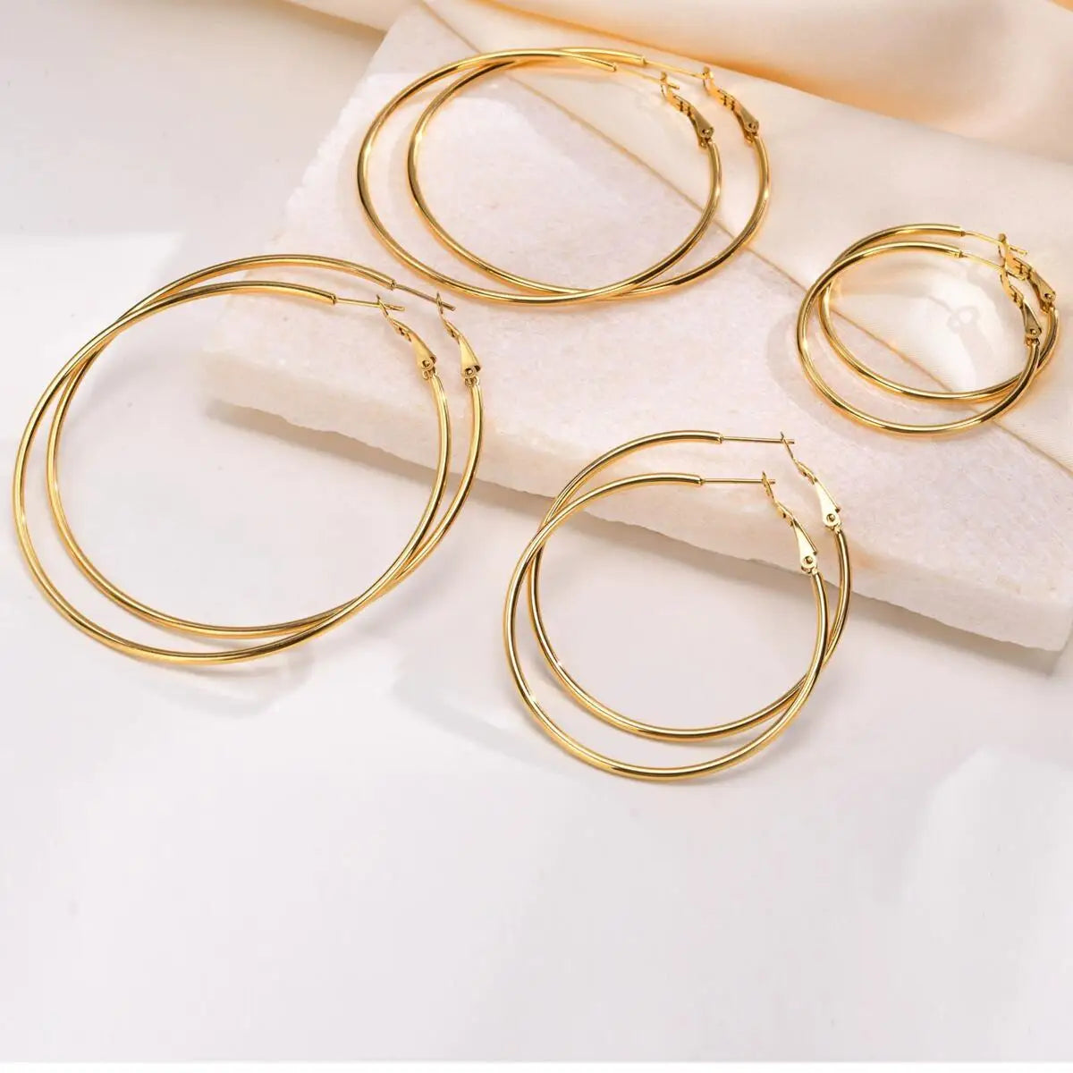 Gold-tone hoop earrings in four sizes, shown from above.