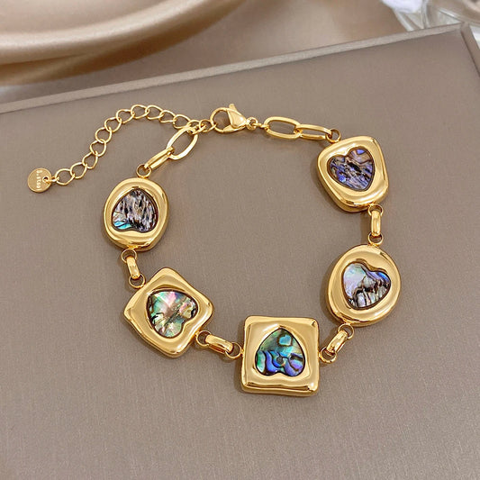 Gold-tone heart charm bracelet with iridescent abalone-shell inlay and geometric links