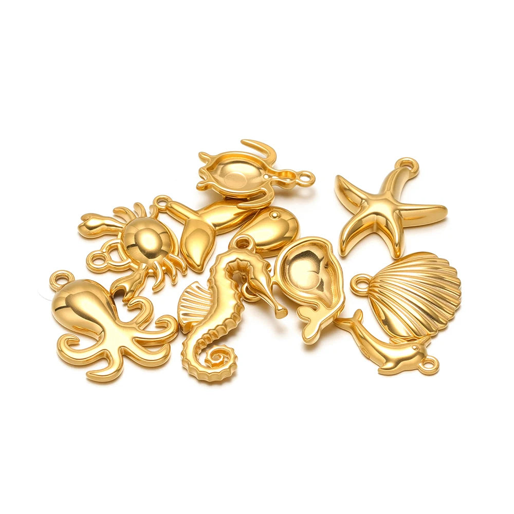 Gold-tone sea animal pendant charms with loops, featuring turtle, starfish, shell, dolphin