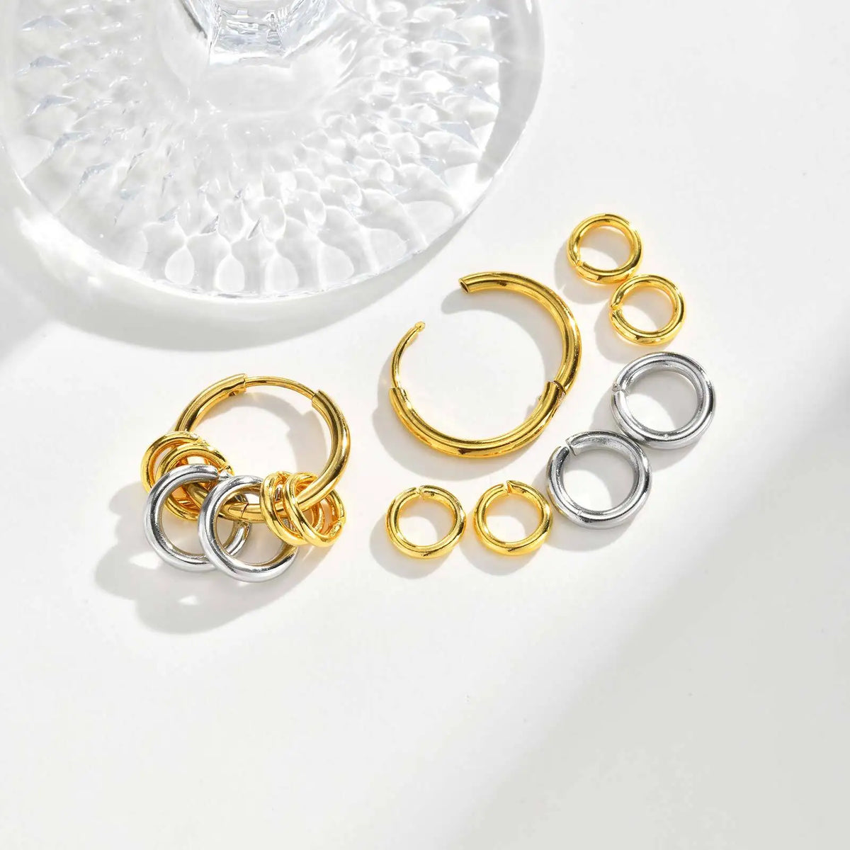 Two-tone hoop earrings shown assembled beside their separate gold and silver rings.
