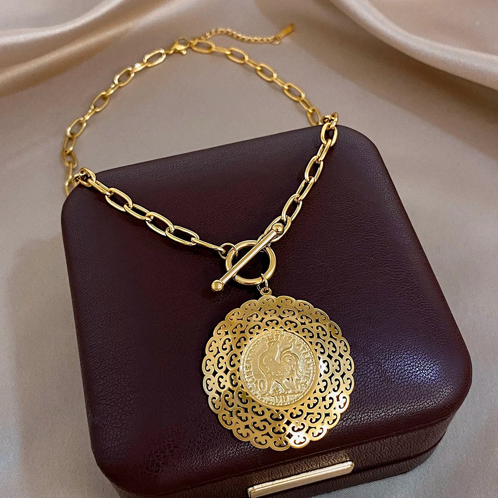 Gold-plated stainless steel necklace with large scalloped filigree heart pendant and coin center