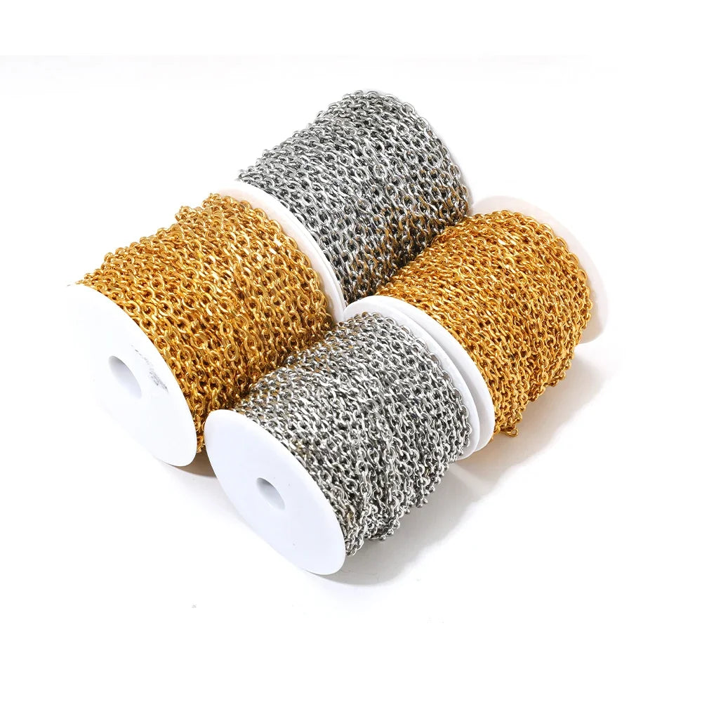 Stacked spools of gold, silver, and darker gold O-link chain with oval links