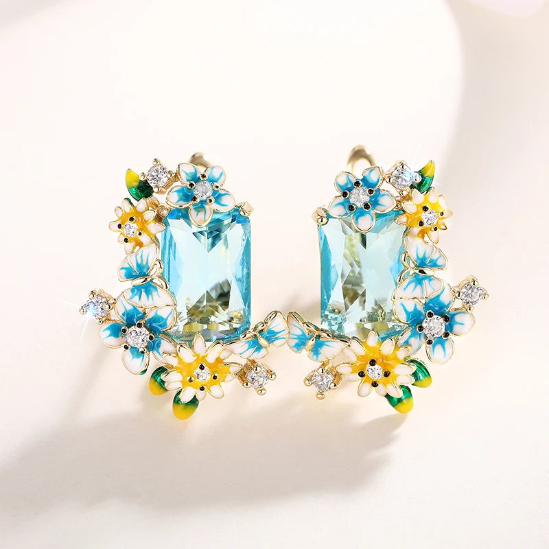 Gold-tone floral drop earrings with aqua crystal drops and layered blue, yellow flower details