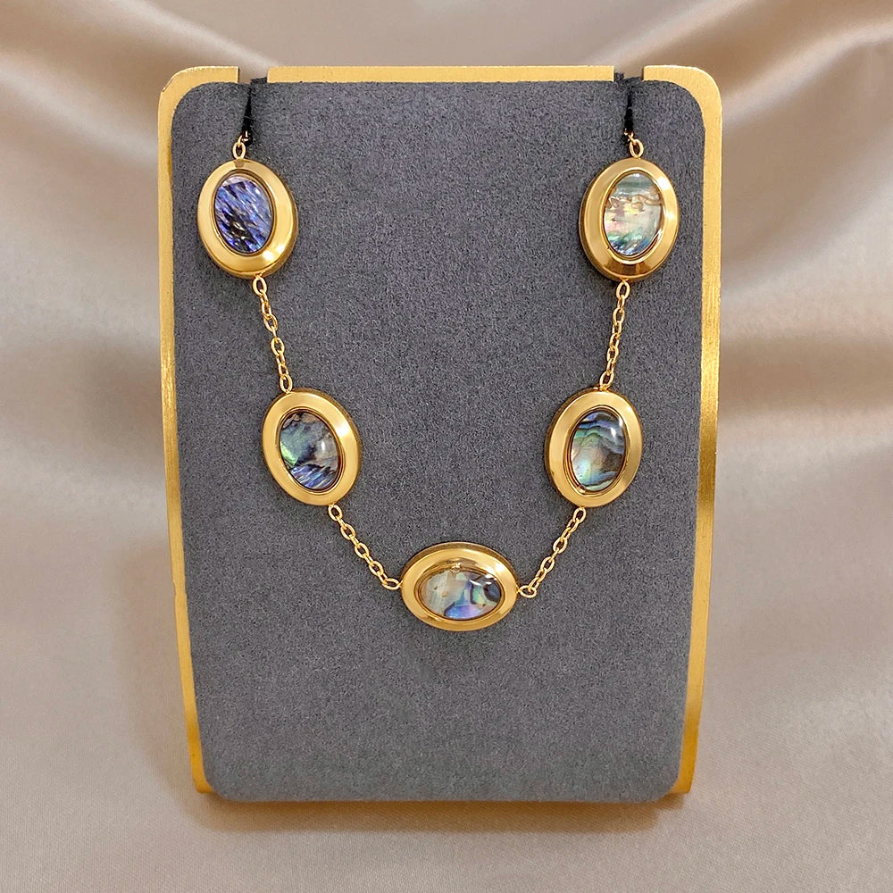Gold plated abalone shell charm bracelet with oval discs on a chain link band