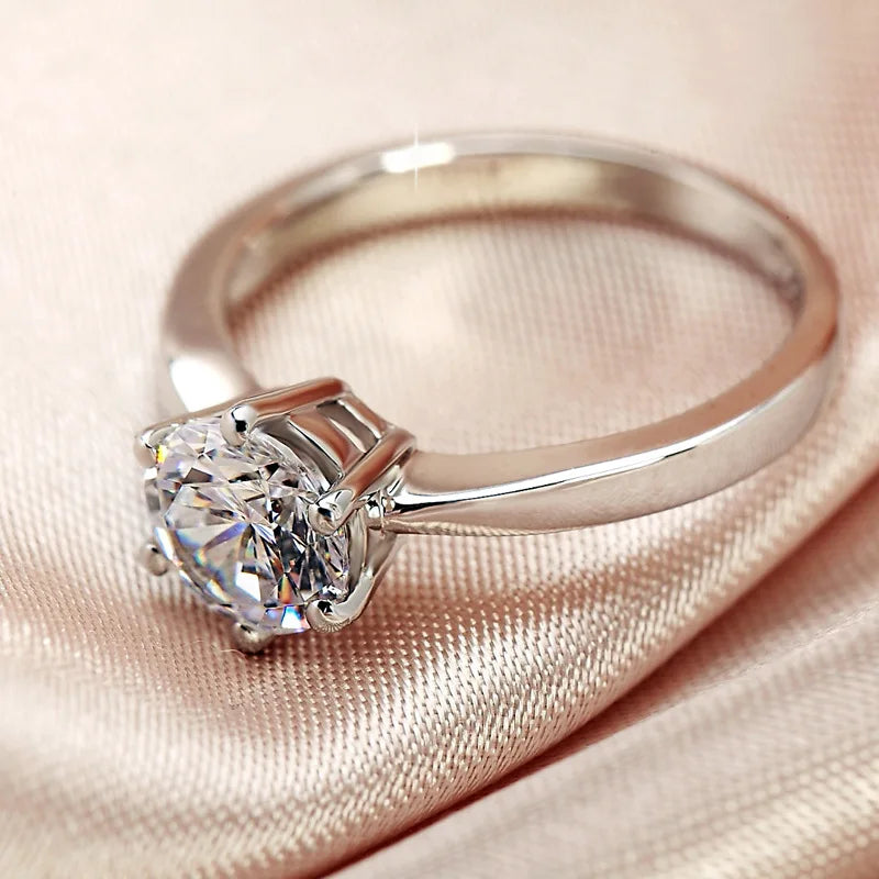 Silver-tone ring with six-prong round cubic zirconia center stone, angled close-up
