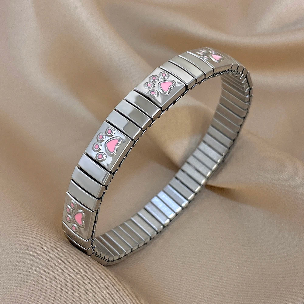 Silver enamel paw print link bracelet bangle with ridged metal center, adjustable fit.