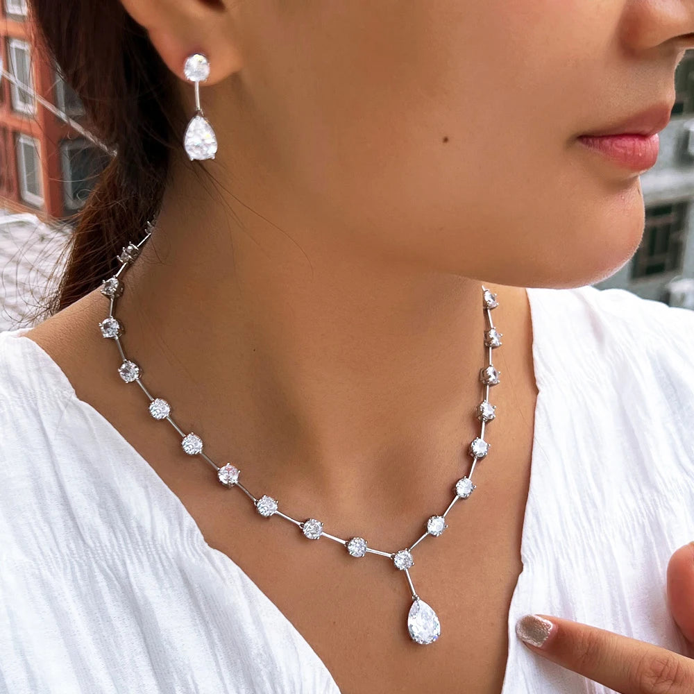 Cubic zirconia necklace and earrings worn by model, silver-tone round stones and teardrop drop