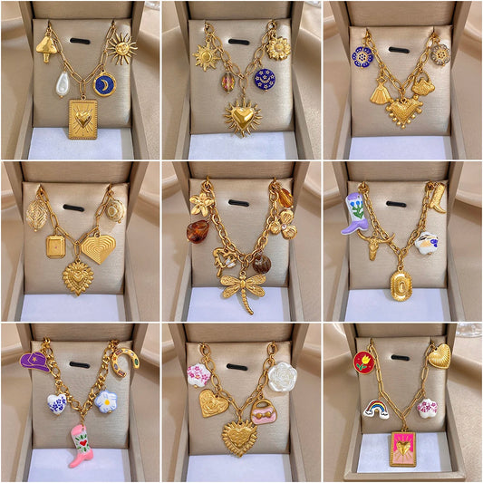 Gold chain necklace with blue heart charm and sunburst and floral pendants