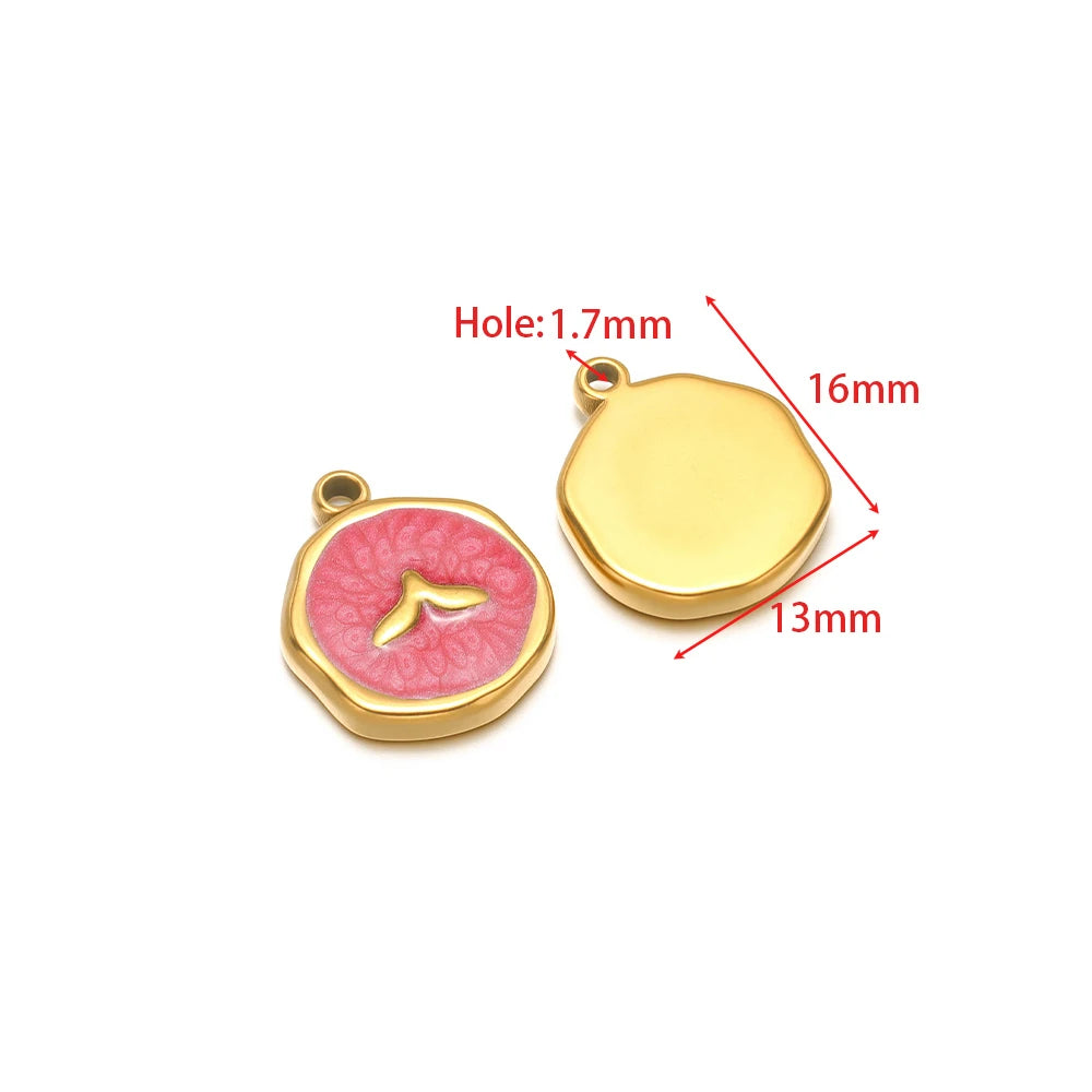 Enamel charm pendant with pink fish motif and gold-tone loop; yellow shell charm